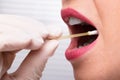 Dentist`s Hand Taking Saliva Test From Woman`s Mouth