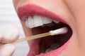 Dentist\'s Hand Taking Saliva Test From Woman\'s Mouth