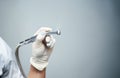 Dentist's hand in white glove is holding the instrument, boron machine