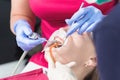 In the dentist`s office. Close-up Examination of the oral cavity of a young female patient by a doctor and assistant Royalty Free Stock Photo