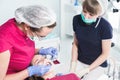 In the dentist`s office. Examination of the oral cavity of a young female patient by a doctor and assistant. Prevention Royalty Free Stock Photo