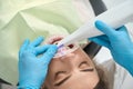 Dentist scanning oral cavity of female patient with medical device