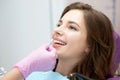 Dentist selecting teeth enamel shade color for young positive woman.