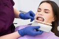 The dentist selects the enamel shade for the womans teeth before the whitening procedure. Royalty Free Stock Photo