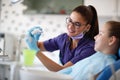 Dentist show to his female patient teeth model in jaw