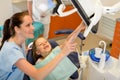 Dentist showing child dental procedure on monitor