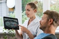 dentist showing and explaining dental x-ray picture with impacted wisdom tooth to his patient Royalty Free Stock Photo