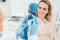 Dentist showing female patient x-ray in modern