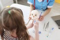 Dentist shows girl how to properly brush her teeth with brush on skull