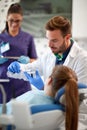 Dentist shows to young girl how to properly brush her teeth