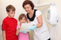 Dentist shows jaw x-ray image for girl and boy