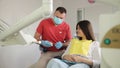 A dentist shows an orthodontic plastic jaw bite to a patient. Health treatment of enamel.