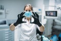 Dentist shows tooth pin and model, dental clinic