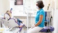 Female dentist sitting next to pateint during teeth whitening procedure