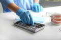 Dentist taking instrument from tray on table