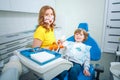 Dentist teaching little boy how to cleaning teeth in dental clinic