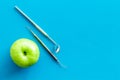 Dentist tools for cure teeth and apple on blue background top view space for text Royalty Free Stock Photo