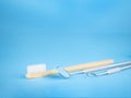 Dentist tools in dental office: dentist mirror and hook, white wooden toothbrush