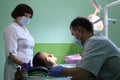 Dentist treating a patient`s teeth with dental tools in dental clinic. Dentistry.