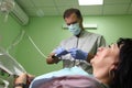 Dentist treating a patient`s teeth with dental tools in dental clinic. Dentistry.