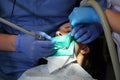 Dentist treating a patient`s teeth with dental tools in dental clinic. Dentistry.