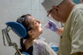 Dentist treats a woman`s teeth, private dental clinic, painless prosthetics at the dentist