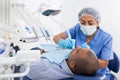 Dentist in uniform is examinating man on chair