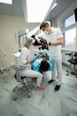 Dentist uses a photo camera to examine a patient