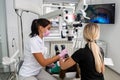 Dentist uses professional equipment to whiten the patient`s teeth in the clinic