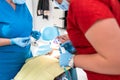 The dentist uses an ultraviolet lamp while fitting the girl with braces