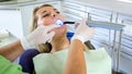 Dentist using dental curing UV light lamp for treatment Royalty Free Stock Photo