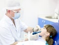 Dentist using dental filling gun on kid