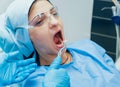 Dentist using surgical pliers to remove a decaying tooth.