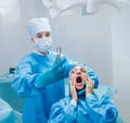 Dentist using surgical pliers to remove a decaying tooth.