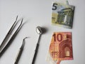 dentist utensils for oral review and european banknotes