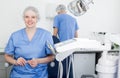 Dentist woman near dental chair, welcoming patient to office