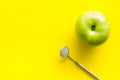 Dentist work desk with mirror and apple on yellow background top view mockup