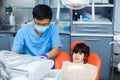 Dentist at work and his little young cheerful patient. Asian doc