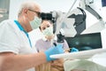 Dentist working with the patient and microscope