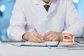 Dentist writes a medical history at a table o