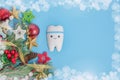 Dentistry banner for Christmas and New Years with tooth model on blue background with Christmas decor with copy space