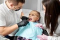 Dentists and assistant pull the tooth to baby with forceps