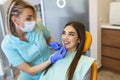 Dentists comparing patient`s teeth shade with samples for bleaching treatment. octor using color samples to show good result afte