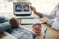 Dentists are discussing dental problems at report x-ray image on laptop screen to patients Royalty Free Stock Photo