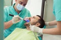 Dentists examining and working on male patient.Dentist`s office.
