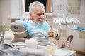 Dentists patient sitting in a dental chair showing thumbs up