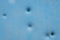 Dents pattern, holes or bullet shot marks on the blue metal surface of the old background iron texture Royalty Free Stock Photo