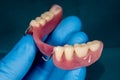 Denture. Partial removable denture of the lower jaw of a person with white beautiful teeth in the hand of a dentist. Aesthetic Royalty Free Stock Photo