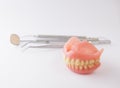 Dentures and dental tools on white background Royalty Free Stock Photo