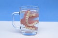 Dentures in a glass glass with water. Use of dentures, problems with teeth Royalty Free Stock Photo